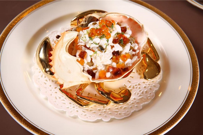 「西施彩蟹柳」以蛋白、皮蛋與新鮮的大沙公蟹肉炒香,綴以鮭魚卵與青蔥,裝入沙公背甲中上桌,色香味俱全。(台北萬豪酒店提供)