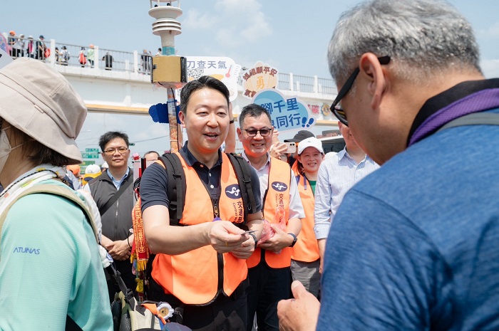 交通部陳世凱部長發放結緣品給現場信眾。(圖/氣象署提供)