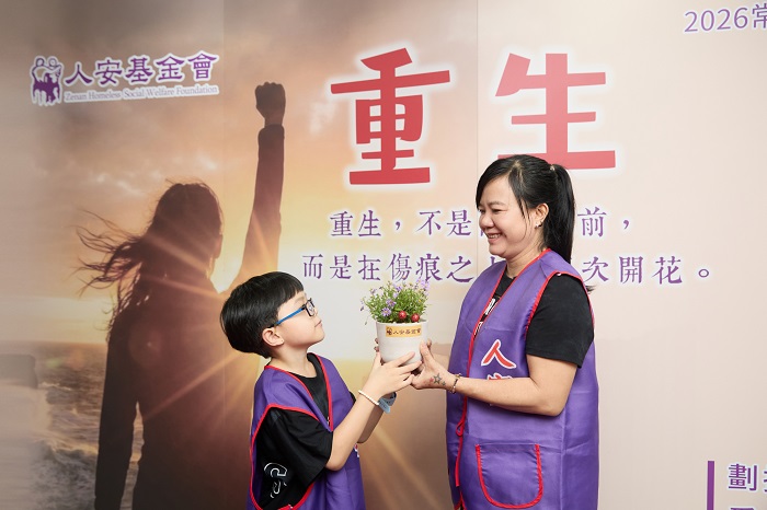 單親媽武女士開心接過兒子做的雛菊花盆。(圖/人安基金會提供)