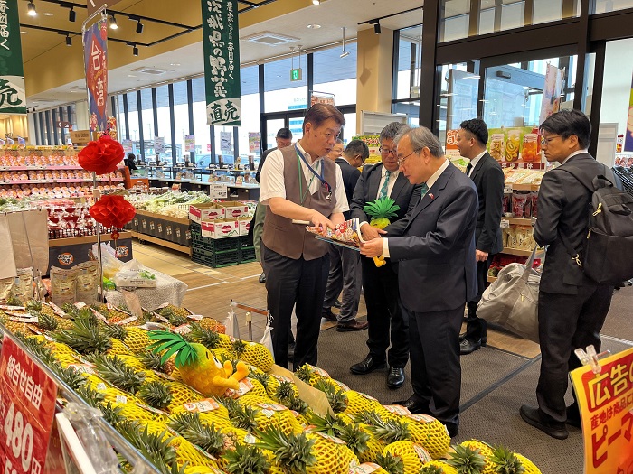 超市水戶元吉店中田厚志店長(左)在訪視臺灣鳳梨銷售時,向農業部胡忠一次長(右)介紹芒果鳳梨行銷策略。